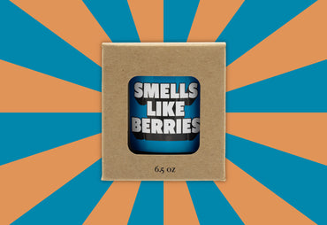 smells like berries blue label candle in box orange background