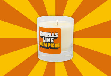 Candle with a label reading 'Smells Like Pumpkin' on a sunburst background