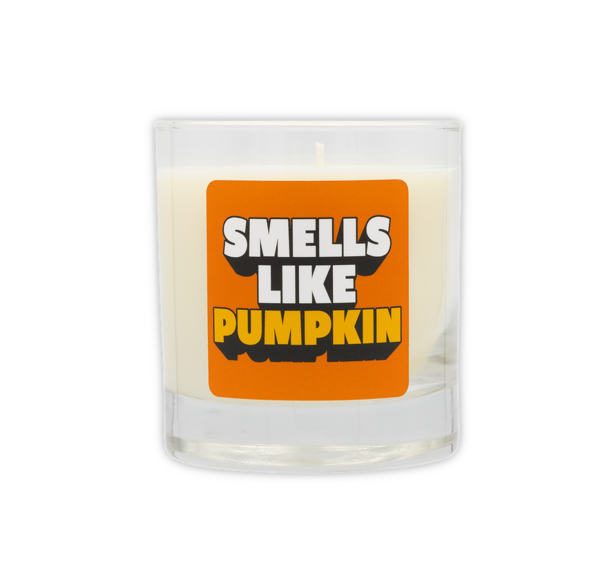 Candle with a label saying 'Smells Like Pumpkin' on a white background