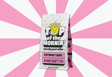 top of the mornin birthday cake coffee bag with sprinkles and pink badge whole bean coffee pink background