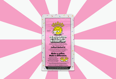 top of the mornin birthday cake coffee bag with sprinkles and pink badge whole bean coffee pink background back of bag