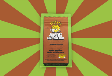 green top of the mornin' coffee bag with orange badge caramel apple flavor back of bag orange and green rays in the background