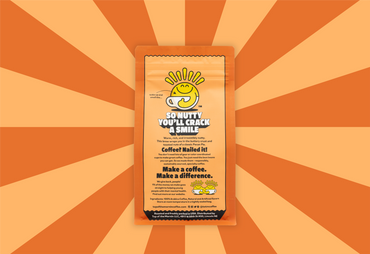 Coffee package with a smiley face design on an orange sunburst background