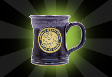 dark purple mug absurdly spooky coffee top of the mornin' written on the front of the mug green glow behind mug and black rays for the background 